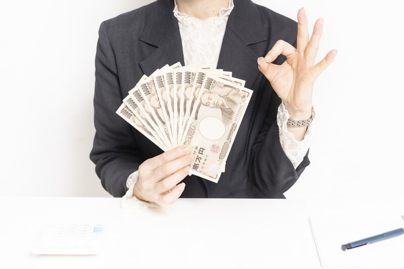 お金を手に持つ女性