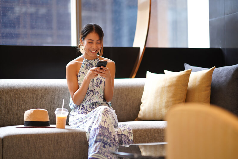 スマホを触る笑顔の女性