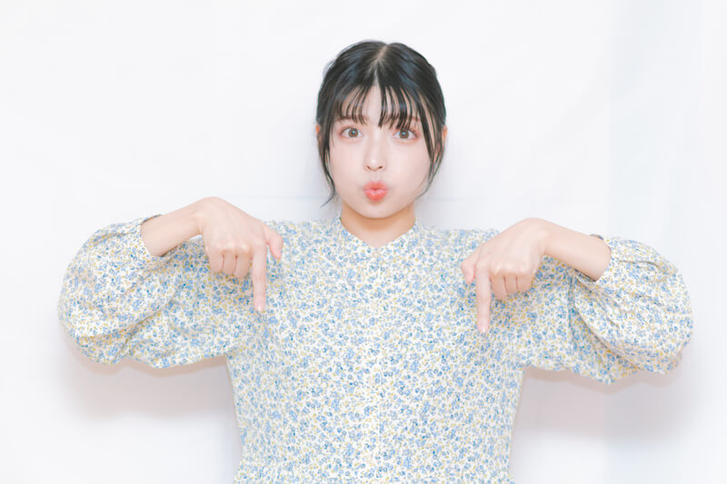 下を指差す女性